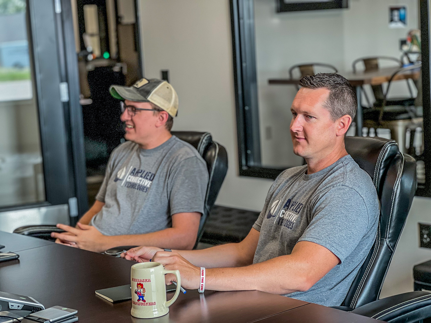 Relationship managers Matt Childress and Travis Petsche talking in conference room of Applied Connective Technologies